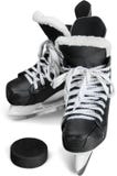 Paires de patins noirs de hockey sur glace avec le galet image stock Paires de patins noirs de hockey sur glace avec le galet image stock