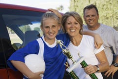 Pais com a filha que guardara o troféu do futebol foto de stock royalty free Pais com a filha que guardara o troféu do futebol foto de stock royalty free