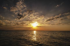 A paisagem de ardência bonita do por do sol no mar Cáspio e no céu alaranjado acima dela com reflexão dourada do sol impressionan Fotografia de Stock A paisagem de ardência bonita do por do sol no mar Cáspio e no céu alaranjado acima dela com reflexão dourada do sol impressionan Fotografia de Stock