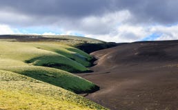 Paisaje dram?tico de Islandia con una colina verde y parecer negros de la lava una luna E fotografía de archivo libre de regalías Paisaje dram?tico de Islandia con una colina verde y parecer negros de la lava una luna E fotografía de archivo libre de regalías