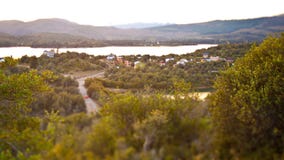 Paisaje inclinable del cambio de una pequeña ciudad al lado de un lago en las montañas foto de archivo libre de regalías Paisaje inclinable del cambio de una pequeña ciudad al lado de un lago en las montañas foto de archivo libre de regalías