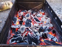 Pal?cy w?gle i ?upk? na grillu uciera Przygotowanie w?giel dla grilla w otwartym grillu Poj?cie zdjęcie stock Pal?cy w?gle i ?upk? na grillu uciera Przygotowanie w?giel dla grilla w otwartym grillu Poj?cie zdjęcie stock