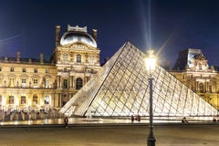 Palacio y pirámides en la noche, París, Francia del Louvre fotografía de archivo Palacio y pirámides en la noche, París, Francia del Louvre fotografía de archivo