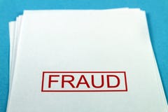 Palavra da fraude em um papel em uma mesa azul foto de stock Palavra da fraude em um papel em uma mesa azul foto de stock