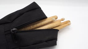 Palillos del tambor y bolsos negros fotografía de archivo libre de regalías Palillos del tambor y bolsos negros fotografía de archivo libre de regalías