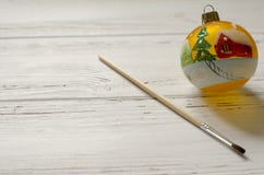Palla dipinta a mano del nuovo anno con la spazzola su fondo di legno bianco fotografia stock libera da diritti Palla dipinta a mano del nuovo anno con la spazzola su fondo di legno bianco fotografia stock libera da diritti