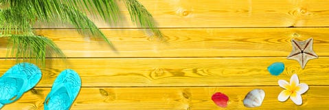 Palm leaf, flip flops and seashells on yellow wooden planks, panoramic beach and summer background royalty free stock photo Palm leaf, flip flops and seashells on yellow wooden planks, panoramic beach and summer background royalty free stock photo