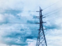 Palo ad alta tensione di energia elettrica sotto la nuvola blu immagini stock Palo ad alta tensione di energia elettrica sotto la nuvola blu immagini stock