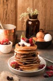 Pancake americani tradizionali saporiti in pila con panna acida, le fragole fresche ed i mirtilli sul piatto bianco vicino alla c fotografie stock libere da diritti Pancake americani tradizionali saporiti in pila con panna acida, le fragole fresche ed i mirtilli sul piatto bianco vicino alla c fotografie stock libere da diritti