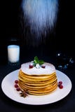 Pancakes on a white plate with cranberry puddings and cinnamon sprinkled with sugar powder along with blueberry jam and stock photography Pancakes on a white plate with cranberry puddings and cinnamon sprinkled with sugar powder along with blueberry jam and stock photography