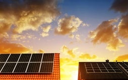 Panel för sol- energi på taket av huset i bakgrundssolnedgånghimlen arkivbilder Panel för sol- energi på taket av huset i bakgrundssolnedgånghimlen arkivbilder