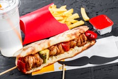 Panino dal pane fresco della pita con il pollo arrostito del raccordo e le verdure, patate fritte su fondo di legno scuro fotografie stock Panino dal pane fresco della pita con il pollo arrostito del raccordo e le verdure, patate fritte su fondo di legno scuro fotografie stock