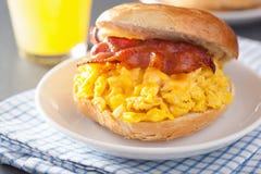 Panino della prima colazione sul bagel con il formaggio del bacon dell'uovo fotografie stock Panino della prima colazione sul bagel con il formaggio del bacon dell'uovo fotografie stock