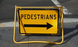 Panneau routier jaune lumineux avec la flèche indiquant la direction piétonnière de déviation images stock Panneau routier jaune lumineux avec la flèche indiquant la direction piétonnière de déviation images stock