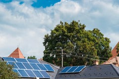 Panneaux photovoltaïques sur la maison residentual, nuages de tempête de ciel bleu photographie stock libre de droits Panneaux photovoltaïques sur la maison residentual, nuages de tempête de ciel bleu photographie stock libre de droits