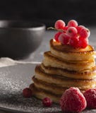 Pannkakor med för mörkerpulver för röd vinbär framdelen för socker fotografering för bildbyråer Pannkakor med för mörkerpulver för röd vinbär framdelen för socker fotografering för bildbyråer