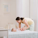 Pannolino cambiante dei baby?s della madre sulla base Pannolino cambiante dei baby?s della madre sulla base