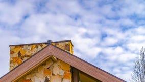 Panorama frame Close up of the roof of a house against trees and sky with cottony clouds royalty free stock photo Panorama frame Close up of the roof of a house against trees and sky with cottony clouds royalty free stock photo