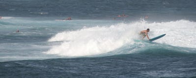 Panorama tirado: Persona que practica surf en una tabla hawaiana imagen de archivo libre de regalías Panorama tirado: Persona que practica surf en una tabla hawaiana imagen de archivo libre de regalías