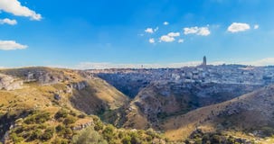 Panoramautsikt av typiska stenar Sassi di Matera och kyrkan av europeisk huvudstad för Matera UNESCO av kultur 2019 under blå him lager videofilmer Panoramautsikt av typiska stenar Sassi di Matera och kyrkan av europeisk huvudstad för Matera UNESCO av kultur 2019 under blå him lager videofilmer