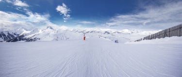 Panoramaview, который нужно кататься на лыжах наклоны и лыжники катаясь на лыжах в лыжном курорте горы Kitzbuehel с предпосылкой Стоковая Фотография RF Panoramaview, который нужно кататься на лыжах наклоны и лыжники катаясь на лыжах в лыжном курорте горы Kitzbuehel с предпосылкой Стоковая Фотография RF