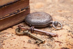 Panta rhei concept: Antique pocket watch, vintage keys and pile of old books on natural cork