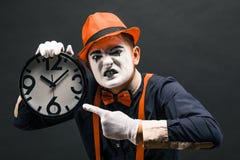 pantomima asustadiza del payaso con un reloj en sus manos, en un backg oscuro fotos de archivo pantomima asustadiza del payaso con un reloj en sus manos, en un backg oscuro fotos de archivo
