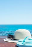 Pantoufles de lunettes de soleil de chapeau sur le fond de mer de ciel bleu et de turquoise Relaxation de voyage de vacances d'ét Photos stock Pantoufles de lunettes de soleil de chapeau sur le fond de mer de ciel bleu et de turquoise Relaxation de voyage de vacances d'ét Photos stock