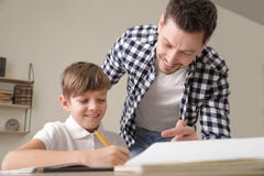Papa aidant son fils avec la t?che d'?cole image libre de droits Papa aidant son fils avec la t?che d'?cole image libre de droits