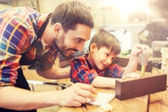 Papa en zoon met heerser die plank meten op workshop stock foto Papa en zoon met heerser die plank meten op workshop stock foto
