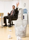 Papel de jogo do homem de negócios na cesta do lixo Fotos de Stock Papel de jogo do homem de negócios na cesta do lixo Fotos de Stock