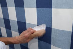 Papel pintado de la ejecución del decorador con la herramienta del trabajo en el movimiento fotografía de archivo Papel pintado de la ejecución del decorador con la herramienta del trabajo en el movimiento fotografía de archivo