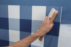 Papel pintado de la ejecución del decorador con la herramienta del trabajo en el movimiento imagen de archivo libre de regalías Papel pintado de la ejecución del decorador con la herramienta del trabajo en el movimiento imagen de archivo libre de regalías