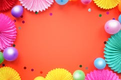 Paper texture flowers with different baloons on orang background. Birthday, holiday or party background. Flat lay style.