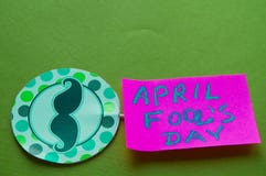 Paper topper with a painted mustache and the words April fool`s day, green background royalty free stock photo Paper topper with a painted mustache and the words April fool`s day, green background royalty free stock photo