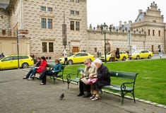 Par av äldre turister sitter på bänken royaltyfri bild Par av äldre turister sitter på bänken royaltyfri bild