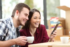 Par genom att använda en telefon, medan rörande, inhyser royaltyfri fotografi Par genom att använda en telefon, medan rörande, inhyser royaltyfri fotografi