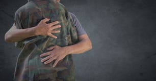 Para trás do soldado que abraça contra o fundo cinzento com folha de prova do grunge fotografia de stock Para trás do soldado que abraça contra o fundo cinzento com folha de prova do grunge fotografia de stock