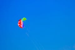 Paracaídas multicolor en el cielo azul fotografía de archivo Paracaídas multicolor en el cielo azul fotografía de archivo