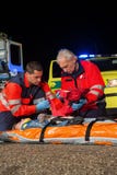 Paramedic team giving firstaid to injured woman Royalty Free Stock Photography Paramedic team giving firstaid to injured woman Royalty Free Stock Photography