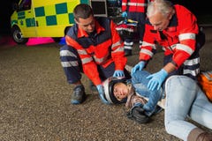 Paramedics που βοηθά τον οδηγό μοτοσικλετών που βρίσκεται στο δρόμο Στοκ φωτογραφίες με δικαίωμα ελεύθερης χρήσης Paramedics που βοηθά τον οδηγό μοτοσικλετών που βρίσκεται στο δρόμο Στοκ φωτογραφίες με δικαίωμα ελεύθερης χρήσης