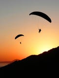 Parapentistes dans le paysage côtier de coucher du soleil Images libres de droits Parapentistes dans le paysage côtier de coucher du soleil Images libres de droits