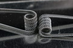 Pare of vaping coils for electronic cigarette or e cig and vape devices metal background Royalty Free Stock Image Pare of vaping coils for electronic cigarette or e cig and vape devices metal background Royalty Free Stock Image