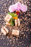 Parecchi cubi del nougat sul piatto dell'ardesia con l'orchidea fioriscono fotografia stock libera da diritti Parecchi cubi del nougat sul piatto dell'ardesia con l'orchidea fioriscono fotografia stock libera da diritti