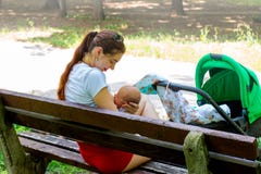 Parent nursing infant in public, pretty mother is gently caring her little baby in the hands, embracing him softly with love royalty free stock photos Parent nursing infant in public, pretty mother is gently caring her little baby in the hands, embracing him softly with love royalty free stock photos