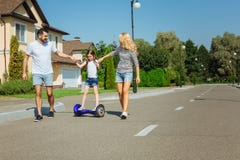 Parents de soin enseignant la fille à monter le hoverboard photos libres de droits Parents de soin enseignant la fille à monter le hoverboard photos libres de droits