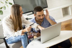 Pares alegres que procuram o Internet e que compram em linha fotografia de stock Pares alegres que procuram o Internet e que compram em linha fotografia de stock