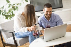 Pares alegres que procuram o Internet e que compram em linha imagem de stock royalty free Pares alegres que procuram o Internet e que compram em linha imagem de stock royalty free