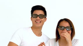 Pares asiáticos de risa que comen las palomitas y que llevan los vidrios de la película metrajes Pares asiáticos de risa que comen las palomitas y que llevan los vidrios de la película metrajes