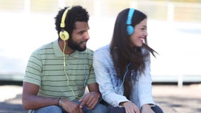 Pares atractivos que se divierten que escucha la música con los auriculares metrajes Pares atractivos que se divierten que escucha la música con los auriculares metrajes